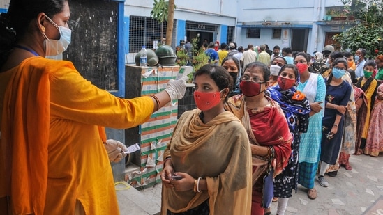 Voters undergo thermal screening for as part of precautions against Covid-19 as they stand in a queue to cast their votes at a polling station during the third phase of West Bengal Assembly elections, at Baruipur in South 24 Parganas district. (PTI) Voters undergo thermal screening for as part of precautions against Covid-19 as they stand in a queue to cast their votes at a polling station during the third phase of West Bengal Assembly elections, at Baruipur in South 24 Parganas district. (PTI)