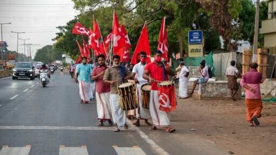 Left Democratic Front supporters waving communist flags play traditional drums during an election campaign in Alappuzha, Kerala.(AP)