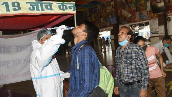 A medic collect swab samples of passengers for Covid-19 testing at Patna Junction on April 4. (Santosh Kumar /Hindustan Times)