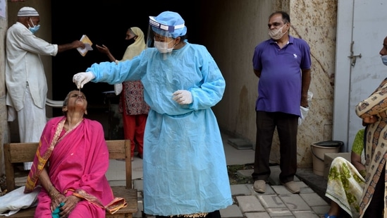 Mumbai, India - April 7, 2021: A BMC health care worker taking a swab smaple from a hawker to test for Covid-19 at Govandi in Mumbai, India, on Wednesday, April 7, 2021. (Photo by Satish Bate/Hindustan Times)(Satish Bate/HT Photo)