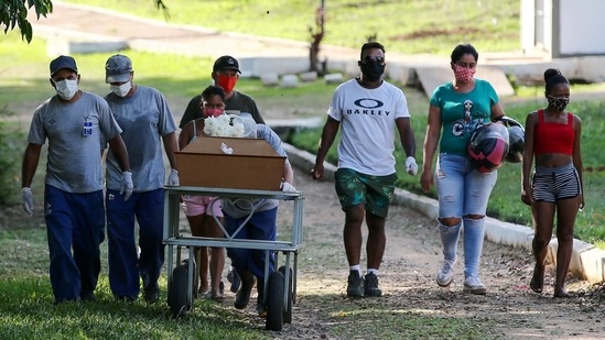 Relatives and gravediggers walk next to the coffin of a Covid-19 victim at Campo Santo cemetery in Porto Alegre on April 6. Miguel Lago, executive director of Brazil's Institute for Health Policy Studies, which advises public health officials, said lifting the lockdown is a mistake and fears that it will bring even higher death numbers, though he thinks it unlikely to be reversed, AP reported.(Diego Vara / REUTERS)