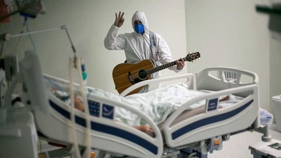 A health worker from a Portuguese charity hospital sings for a Covid-19 patient inside the hospital ward in Belem, Para State on April 4. Covid-19 patients are using more than 90% of beds in intensive care unit in most Brazilian states, though figures have been stable since the past week, AP reported.(Tarso Sarraf / AFP)