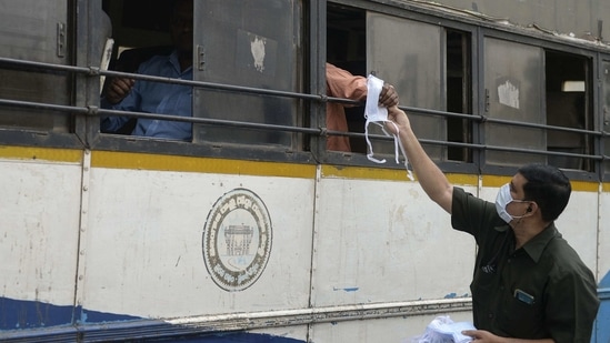 A health worker distributes facemask to bus passengers during an awareness campaign against the spread of the Covid-19 coronavirus on World Health Day, at a traffic junction in Hyderabad on April 7, 2021. (AFP) A health worker distributes facemask to bus passengers during an awareness campaign against the spread of the Covid-19 coronavirus on World Health Day, at a traffic junction in Hyderabad on April 7, 2021. (AFP)