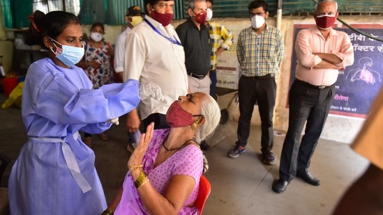 A BMC medical staff collects a swab sample for Covid-19 test from a person in Mumbai on Thursday. (Anshuman Poyrekar/HT Photo)