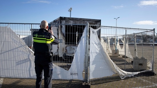 FILE - In this Jan. 24, 2021, file photo, a police officer takes pictures of a burned-out coronavirus testing facility in the fishing village of Urk in the Netherlands after it was set on fire the night before by rioting youths protesting on the first night of a nationwide curfew. Prosecutors in the Netherlands said Thursday April 8, 2021, that police arrested a 37-year-old man on suspicion of plotting a crime with "terrorist intent" for allegedly plotting to set off what they described as a "firework bomb" at a coronavirus vaccination center in Den Helder, northern Netherlands. (AP Photo/Peter Dejong, File) (AP) FILE - In this Jan. 24, 2021, file photo, a police officer takes pictures of a burned-out coronavirus testing facility in the fishing village of Urk in the Netherlands after it was set on fire the night before by rioting youths protesting on the first night of a nationwide curfew. Prosecutors in the Netherlands said Thursday April 8, 2021, that police arrested a 37-year-old man on suspicion of plotting a crime with "terrorist intent" for allegedly plotting to set off what they described as a "firework bomb" at a coronavirus vaccination center in Den Helder, northern Netherlands. (AP Photo/Peter Dejong, File) (AP)