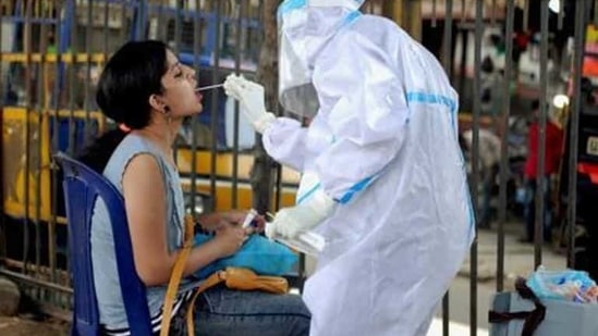 A health worker wearing a PPE kit collects a sample from a woman for the Covid-19 Rapid Antigen Test. A health worker wearing a PPE kit collects a sample from a woman for the Covid-19 Rapid Antigen Test.
