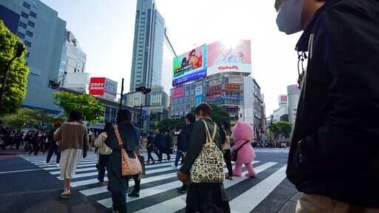 People wearing protective masks to help curb the spread of the coronavirus walk along a pedestrian crossing in Shibuya district Wednesday, April 7, 2021, in Tokyo. The Japanese capital confirmed more than 550 new coronavirus cases on Wednesday. (AP Photo/Eugene Hoshiko)(AP) People wearing protective masks to help curb the spread of the coronavirus walk along a pedestrian crossing in Shibuya district Wednesday, April 7, 2021, in Tokyo. The Japanese capital confirmed more than 550 new coronavirus cases on Wednesday. (AP Photo/Eugene Hoshiko)(AP)