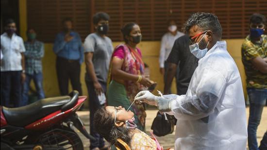 A health worker collects a swab sample from a woman for Covid-19 test, in Mumbai on April 7. (PTI)