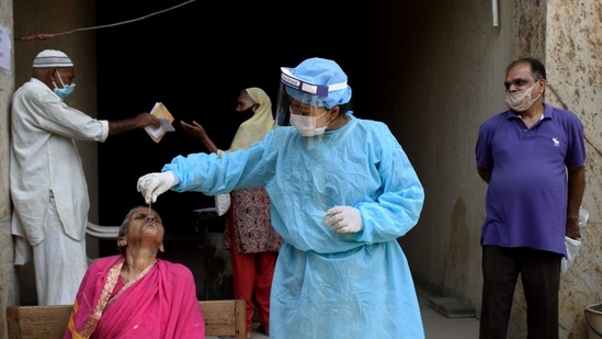 Mumbai, India - April 7, 2021: A BMC health care worker taking a swab smaple from a hawker to test for Covid-19 at Govandi in Mumbai(Satish Bate/HT Photo) Mumbai, India - April 7, 2021: A BMC health care worker taking a swab smaple from a hawker to test for Covid-19 at Govandi in Mumbai(Satish Bate/HT Photo)