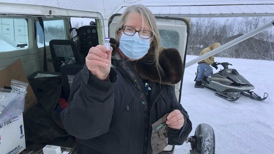 Village Service Chief Dr. Elizabeth Roll holds a Covid-19 vaccine in Napakiak, Alaska in December 2020. In the rough and roadless terrain of southwestern Alaska, the Yukon-Kuskokwim Health Corp. chartered planes and used snowmobiles last year winter to deliver the vaccine to nearly four dozen villages spread out over an area the size of Oregon. (Yukon Kuskokwim Health Corporation via AP) Village Service Chief Dr. Elizabeth Roll holds a Covid-19 vaccine in Napakiak, Alaska in December 2020. In the rough and roadless terrain of southwestern Alaska, the Yukon-Kuskokwim Health Corp. chartered planes and used snowmobiles last year winter to deliver the vaccine to nearly four dozen villages spread out over an area the size of Oregon. (Yukon Kuskokwim Health Corporation via AP)