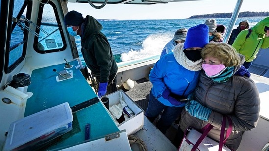 Nurses Kathy Cheney (2L), and Maureen Giffen huddle on a wet and windy ride aboard a lobster boat on the way to set up a Covid-19 vaccination clinic on March 19 on Great Cranberry Island, Maine. For islanders, getting to the mainland in the best of circumstances would’ve meant a daylong trip to get the vaccine. Rough weather can delay ferries and mailboats, leaving residents stuck for days. And some are too infirm to travel. (Robert F. Bukaty/AP) Nurses Kathy Cheney (2L), and Maureen Giffen huddle on a wet and windy ride aboard a lobster boat on the way to set up a Covid-19 vaccination clinic on March 19 on Great Cranberry Island, Maine. For islanders, getting to the mainland in the best of circumstances would’ve meant a daylong trip to get the vaccine. Rough weather can delay ferries and mailboats, leaving residents stuck for days. And some are too infirm to travel. (Robert F. Bukaty/AP)