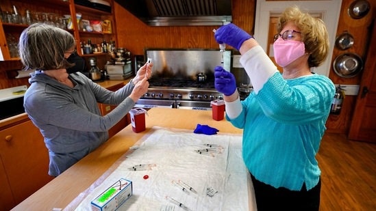 Nurses Sharon Daley (L), and Maureen Giffen fill syringes with the Moderna Covid-19 vaccine in a makeshift clinic in the kitchen of a community center on March 19 on Great Cranberry Island, Maine. Just like in other parts of the world, including the US, health care workers had to overcome the challenge of persuading some people that it was safe and important to get the shot, AP reported. (Robert F. Bukaty/AP) Nurses Sharon Daley (L), and Maureen Giffen fill syringes with the Moderna Covid-19 vaccine in a makeshift clinic in the kitchen of a community center on March 19 on Great Cranberry Island, Maine. Just like in other parts of the world, including the US, health care workers had to overcome the challenge of persuading some people that it was safe and important to get the shot, AP reported. (Robert F. Bukaty/AP)