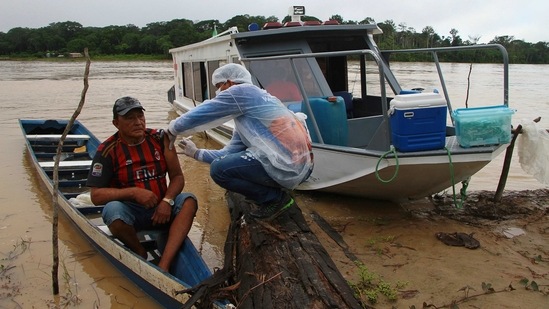 Luis Alves Nogueira, 74, receives a dose of the Oxford-AstraZeneca Covid-19 vaccine from a healthcare worker, in the Pupuri community along the Purus River, in Amazonas state, Brazil on February 12. In Brazil, remote Amazon communities presented a challenge that meant traveling for hours on small planes and boats. (Edmar Barros/AP) Luis Alves Nogueira, 74, receives a dose of the Oxford-AstraZeneca Covid-19 vaccine from a healthcare worker, in the Pupuri community along the Purus River, in Amazonas state, Brazil on February 12. In Brazil, remote Amazon communities presented a challenge that meant traveling for hours on small planes and boats. (Edmar Barros/AP)