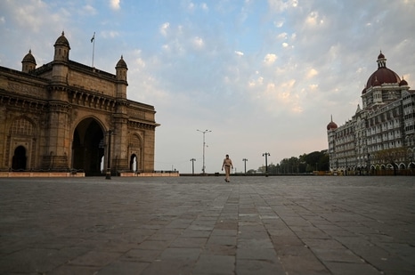 A policewoman walks through a deserted area between the Gateway of India and Taj Mahal Hotel ahead of the scheduled weekend lockdown imposed by the state government amidst rising Covid-19 coronavirus cases in Mumbai. (AFP)
