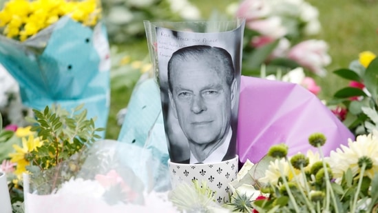 A picture of Britain's Prince Philip is placed among flowers outside Windsor Castle, following his death at the age of 99, in Windsor, near London on April 10, 2021(Reuters Photo)