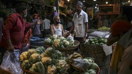 Shoppers buying vegetables from stalls at the Dadar wholesale vegetable market during the lockdown on April 10. The guidelines circulated have allowed all Agriculture Produce Marketing Committee (AMPC) markets to remain open during weekend lockdown, provided they ensure strict adherence of Covid-appropriate behaviour.(Dhiraj Singh/Bloomberg)