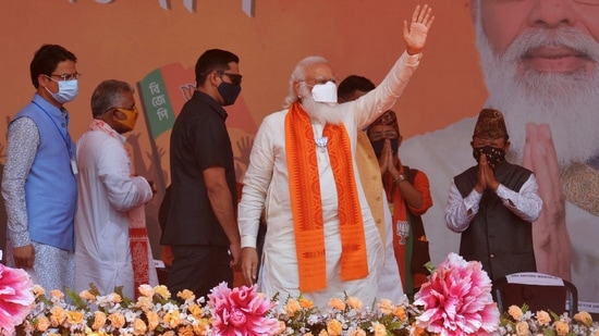 Indian Prime Minister Narendra Modi (C) waves to supporters in a rally meeting during the ongoing Phase 4 of West Bengal's assembly election, at Kawakhali on the outskirts of Siliguri on April 10, 2021. (AFP)