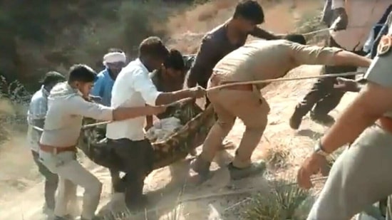 People and police personnel carry injured to ambulance. (SOURCED)
