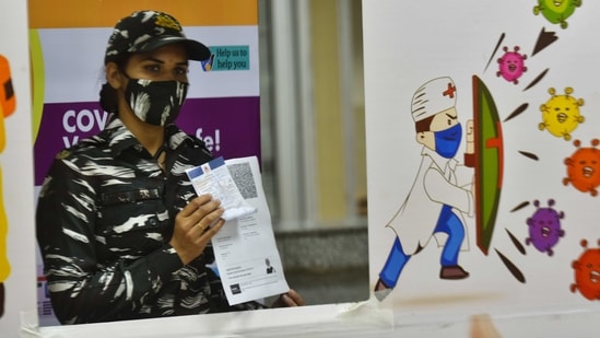 A security personnel gets photographed after being vaccinated against Covid-19, at LNJP Hospital in New Delhi on April 10. According to data by Our World in Data, India is the fastest to 100 million vaccinations. It took the country 85 days to reach the milestone. The US took 89 days to complete this feat, while China did so in 103 days.(Sanchit Khanna / HT Photo)