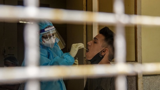 A health worker in PPE takes swab samples from a boy for RT PCR COVID 19 test, at a government hospital, in New Delhi. (ANI) A health worker in PPE takes swab samples from a boy for RT PCR COVID 19 test, at a government hospital, in New Delhi. (ANI)