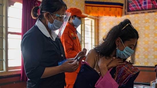 A health worker inoculate a dose of a COVID-19 coronavirus vaccine to a woman during the first day of vaccination in Bhutan, at Lungtenzampa Middle Secondary school in Thimphu on March 27, 2021. (Photo by Upasana DAHAL / AFP)(AFP)