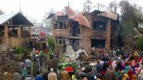 Locals stand near a damaged building after a clash between militants and army personnel, in Anantnag District,(PTI) Locals stand near a damaged building after a clash between militants and army personnel, in Anantnag District,(PTI)