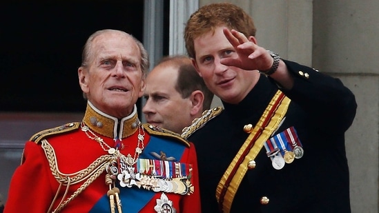 In this June 14, 2014 file photo, Britain's Prince Harry talks to Prince Philip as members of the Royal family appear on the balcony of Buckingham Palace, during the Trooping The Colour parade, in central London. (AP)