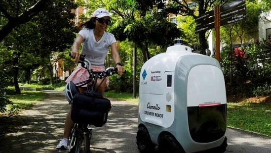 A cyclist passes as Camello, an autonomous grocery delivery robot, makes its way during a delivery in Singapore April 6, 2021. (Reuters)