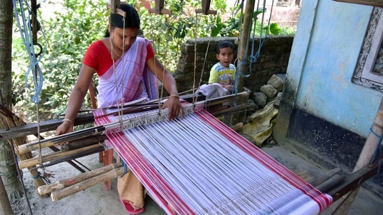 A woman weaving an Assamese traditional Gamosa ahead of the Rongali Bihu festival, in Nagaon on Sunday. (ANI Photo)