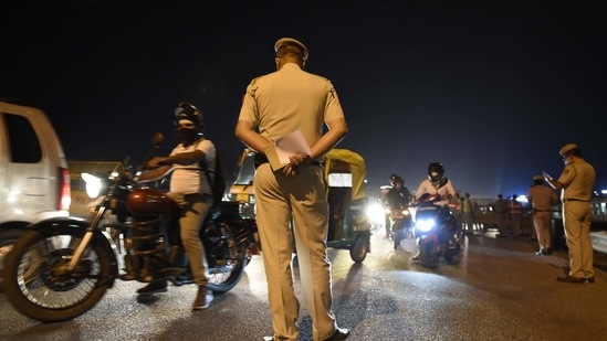 Delhi Police personnel screen commuters for necessary documents during night curfew hours imposed by the state government in wake of the rising coronavirus cases, at Sarhaul border near Udyog Vihar, in Gurugram, India.