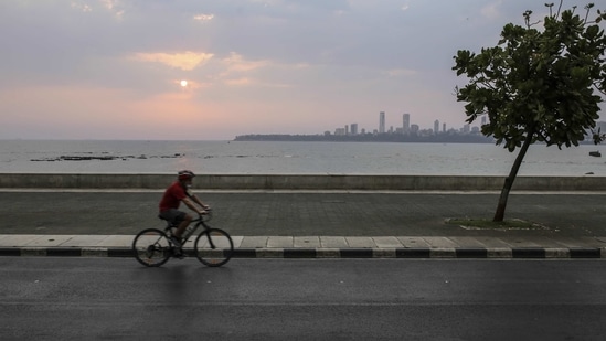 A cyclist travels along a deserted Marine Drive during a weekend lockdown in Mumbai.(Bloomberg)