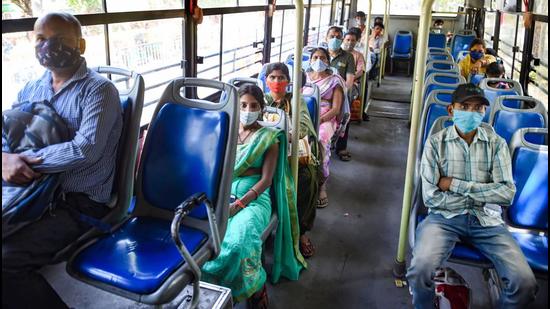 Passengers maintain social distancing while sitting in a bus, as DTC buses operate at 50% capacity, in New Delhi on April 11. (PTI)