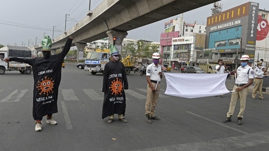 Policemen wearing dress themed on Covid-19 coronavirus and holding a gigantic facemask urge commuters to wear facemasks during an awareness campaign at a traffic junction in Hyderabad on April 9, 2021, as India surged past 13 million coronavirus cases. (AFP) Policemen wearing dress themed on Covid-19 coronavirus and holding a gigantic facemask urge commuters to wear facemasks during an awareness campaign at a traffic junction in Hyderabad on April 9, 2021, as India surged past 13 million coronavirus cases. (AFP)