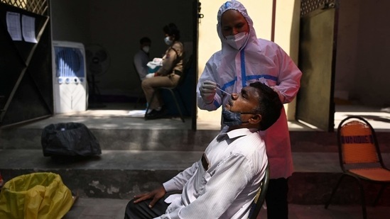 A healthcare worker takes a swab sample from a man for RT-PCR test, at a testing centre in New Delhi. (AFP Photo) A healthcare worker takes a swab sample from a man for RT-PCR test, at a testing centre in New Delhi. (AFP Photo)