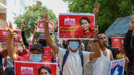 Anti-coup protesters flash the three-fingered symbol of resistance while holding slogans bearing pictures of deposed leader Aung San Suu Kyi during a demonstration in Yangon.(AP) Anti-coup protesters flash the three-fingered symbol of resistance while holding slogans bearing pictures of deposed leader Aung San Suu Kyi during a demonstration in Yangon.(AP)