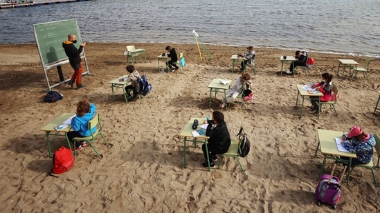 A teacher teaches a class to students of the Felix Rodriguez de la Fuente school, as part of a project known as 'Aire Limpio' (Fresh Air) at the Playa de los Nietos (The Grandchildren's Beach), which aims to use better air quality for children during the coronavirus disease (COVID-19) pandemic, near Cartagena, southern Spain April 8, 2021. Picture taken April 8, 2021. REUTERS/Nacho Doce (REUTERS)