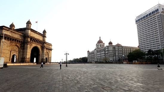 A deserted view of the road in front of the Gateway of India, Taj Mahal Palace, and The Oberai Hotel during a weekend lockdown, in Mumbai on Sunday. (ANI Photo) A deserted view of the road in front of the Gateway of India, Taj Mahal Palace, and The Oberai Hotel during a weekend lockdown, in Mumbai on Sunday. (ANI Photo)