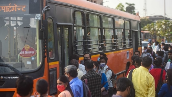 Commuters attempt to board a DTC bus while flouting social distancing norms, at Krishi Bhawan in New Delhi on Monday.(Amal KS/HT Photo)