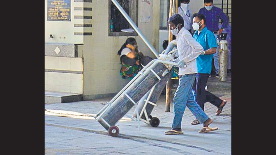 Workers transport oxygen cylinders to civic hospital, in Thane. (Praful Gangurde / HT Photo) Workers transport oxygen cylinders to civic hospital, in Thane. (Praful Gangurde / HT Photo)