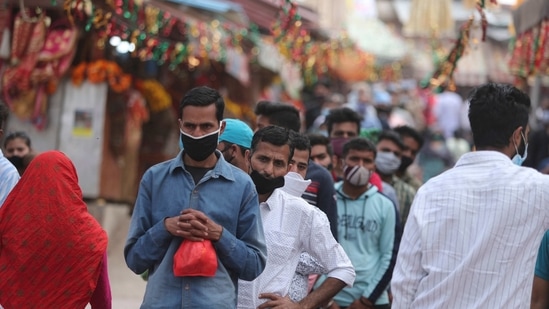 Hindu devotees wearing face masks as a precautionary measure against the coronavirus stand in a queue to offer prayers inside a temple dedicated to goddess Kali in Jammu, India, Tuesday, April 13, 2021. (AP)