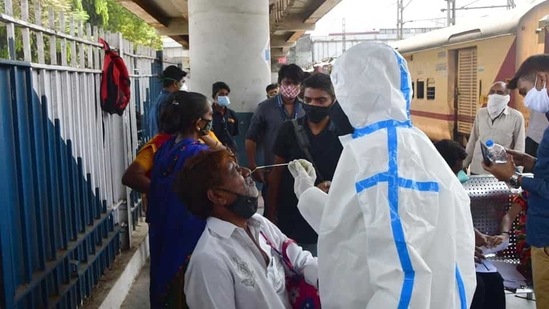 A health worker wearing protective gear conducts Rapid Antigen test for Covid-19 of passengers. (Bhushan Koyande/ HT Photo)