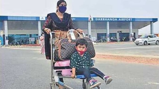 A woman carries her child on a luggage trolley from the civil enclave to the airport on Monday. (HT Photo) A woman carries her child on a luggage trolley from the civil enclave to the airport on Monday. (HT Photo)