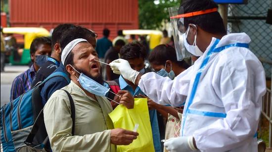 A health worker collects samples for Covid-19 tests at Bengaluru City Railway Station, amid a huge surge in coronavirus cases in Bengaluru on Wednesday. (PTI PHOTO.) A health worker collects samples for Covid-19 tests at Bengaluru City Railway Station, amid a huge surge in coronavirus cases in Bengaluru on Wednesday. (PTI PHOTO.)