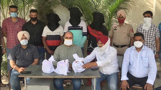 The three accused and the seized contraband in the custody of Ludhiana police. (HT Photo)