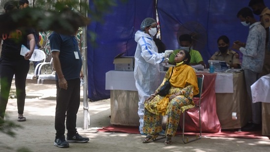 A health worker in PPE coveralls seen collecting swab samples for Covid-19 testing at Mehrauli in New Delhi on April 13. Delhi’s positivity rate also jumped to 13.14% on April 13, despite the city testing over 100,000 people for the infection once again. This is the highest positivity rate in the city since 15.33% on November 15, when cases hit their third-wave peak. (Sanchit Khanna / HT Photo)