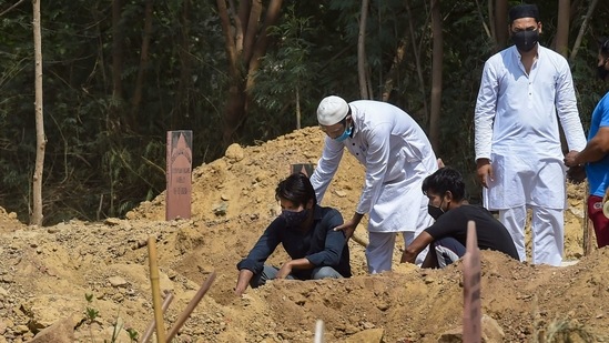 Family members and relatives performing the burial of a person who succumbed to Covid-19, at a graveyard in New Delhi on April 13. The health bulletin on April 13 also showed that the infection claimed 81 more lives in Delhi — the most in a day since December 3, when 82 people died of Covid-related complications. Over the last three days, 201 people in Delhi have died of the infection. It took the Capital 10 days to register the previous 200 fatalities. (Manvender Vashisht / PTI)