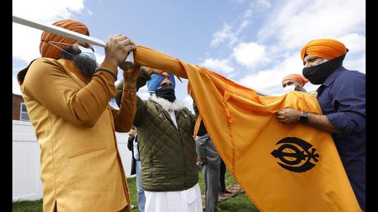 Sikhs at the ceremonial changing of the Sikh flag (Nishan Sahib) during Baisakhi celebrations at Guru Nanak Darbar of Long Island in Hicksville, NY. (AP Photo)