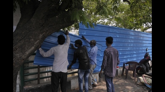 Tin sheets being installed to block the view of Bhainsakund cremation site in Lucknow. (Deepak Gupta/HT Photo)