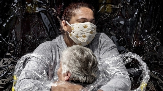 In this image released by World Press Photo, Thursday April 15, 2021, by Mads Nissen, Politiken, Panos Pictures, which won the World Press Photo of the Year award, and the first prize in the General News Singles category, titled The First Embrace, shows Rosa Luzia Lunardi (85) embraced by nurse Adriana Silva da Costa Souza, at Viva Bem care home, Sao Paulo, Brazil, on August 5, 2020. (Mads Nissen, Politiken, Panos Pictures, World Press Photo via AP)