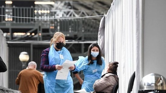 Medical workers chat with patients before their vaccination with the Pfizer/BioNTech vaccine against the Covid-19 at a centre in Paris, as part of France's vaccination campaign aimed at curbing the spread of the Covid-19 pandemic.